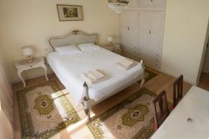 波尔图布尔戈之家度假屋的卧室配有一张白色床和2个地毯