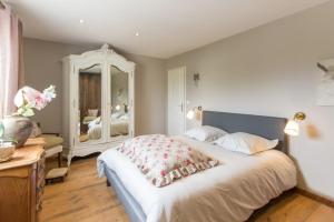 Tour-en-BessinLe Domaine de Prune的一间卧室设有一张大床和一个大镜子