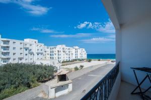 甘达坞伊港Résidence Sayadi - Chatt Meriam - Sousse的享有海滩和建筑景致的阳台