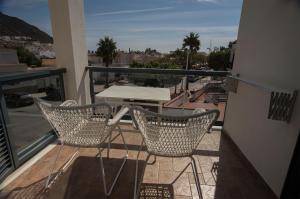圣何塞Hotel La Posada De Paco - Spa & Adults Friendly的阳台配有两把椅子和一张桌子