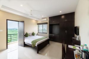 钦奈Treebo Adin Residence Chennai Trade Centre的一间卧室设有一张床和一个大窗户