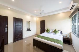 钦奈Treebo Trend Adin Residence Chennai Trade Centre的一间卧室设有一张大床和一个窗户。