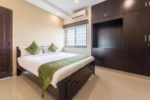 钦奈Treebo Adin Residence Chennai Trade Centre的一间卧室配有一张大床和一台平面电视