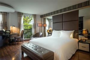 河内La Nueva Boutique Hotel Hanoi & Spa的卧室配有一张白色大床和一张书桌