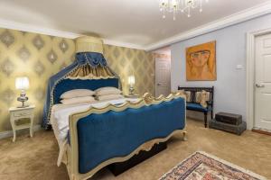 努沃勒埃利耶肯特小屋酒店的一间卧室配有蓝色床和蓝色天蓬