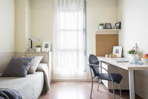 毕尔巴鄂布拉斯德奥特罗君悦大学旅舍的一间卧室配有一张床和一张桌子及椅子