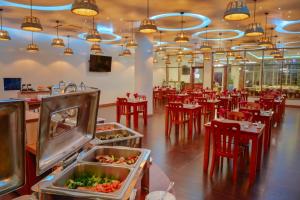 图鲁斯杜季节天堂酒店的一间设有红色桌椅的餐厅以及一间自助餐