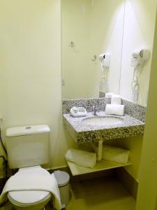 伊塔佩米林河畔卡舒埃鲁Easy Hotel Cachoeiro de Itapemirim by Atlantica的浴室设有卫生间和带镜子的盥洗盆