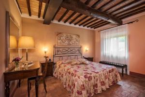 巴尼奥维尼奥尼Relais Osteria Dell'Orcia的一间卧室配有一张床、一张桌子和一张书桌