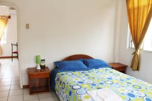 阿约拉港The Finch House (La Casa del Pinzón)的一间卧室配有蓝色和黄色床单