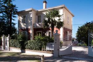 乌尔比诺Residenza Ambrogi的一座白色的房子,有门和棕榈树