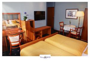 皮塞克康迪别墅酒店的酒店客房配有一张床、一张书桌和一台电视。