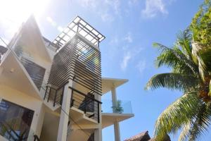 长滩岛Boracay White Coral Hotel的带阳台的白色建筑和棕榈树
