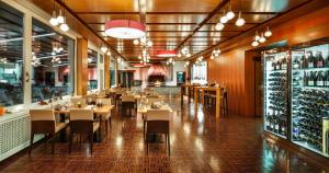 贝肯里德泽拉什瑞士优质酒店的一间带桌椅和葡萄酒瓶的餐厅