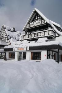 施马伦贝格Pension & Ferienhaus Latröpchen的积雪覆盖的建筑物