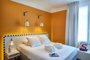 布雷斯特旅客酒店 - 布雷斯特中心的一间卧室配有白色的床和橙色的墙壁