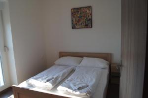 什图罗沃apartman Panorama的一张铺有白色床单的床和一张墙上的照片