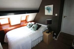 圣比斯Lulus的一间卧室配有白色床和蓝色枕头