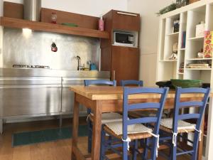 罗马卡萨布兰卡公寓 的厨房配有木桌和蓝色椅子