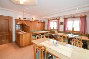 萨尔巴赫菲林霍夫埃德沃夫巴尔旅馆的用餐室配有木桌和椅子