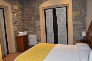 赫罗纳历史公寓酒店的一间卧室设有一张床和石墙