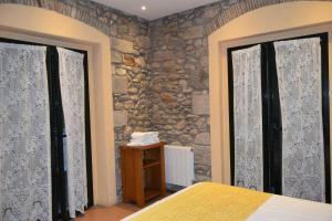 赫罗纳历史公寓酒店的一间卧室设有两扇窗户和石墙