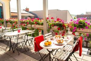 柏林米库隆伊斯特盖特酒店（市中心店）的两把桌子和椅子,位于带鲜花的阳台