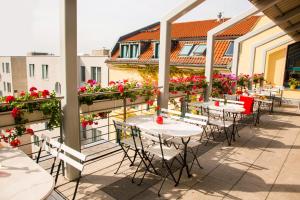 柏林米库隆伊斯特盖特酒店（市中心店）的一个带桌椅的庭院,阳台种有鲜花