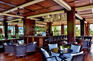 帕洋安巴厘岛空中花园别墅的一间带桌椅的餐厅和一间酒吧