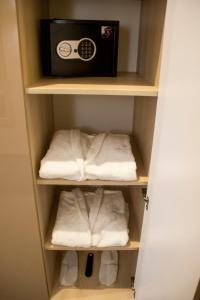 卢茨克Hotel Versailles的衣柜里配有毛巾和收音机