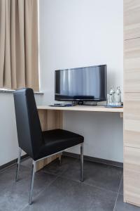 AllhamingTurmöl Hotel的一张桌子、一台电视和一张黑椅子
