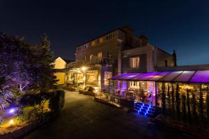 圣赫利尔泽西萨伏伊酒店的一座晚上有紫色灯光的建筑