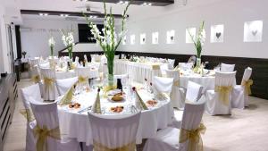 佩济诺克维那斯基大教堂酒店的用餐室配有白色的桌子和白色的椅子