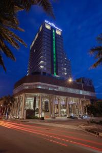 马尼拉Acacia Hotel Manila的上面有绿色标志的建筑