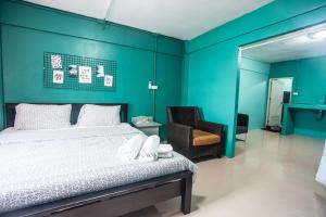 甲米镇您好公寓的一间卧室设有一张床和蓝色的墙壁