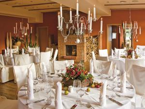 马尔肖罗森杜密兹酒店的一间配备有白色桌椅和吊灯的餐厅