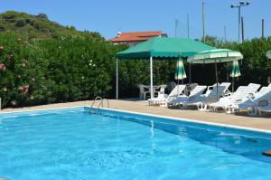 坎普码头Pozzo al Moro Village的游泳池旁设有椅子和遮阳伞