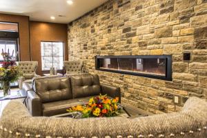 奇珀瓦福尔斯Cobblestone Hotel & Suites - Chippewa Falls的客厅设有带壁炉的石墙