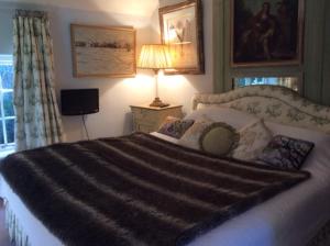 米德赫斯特Bridge Cottage的一间卧室配有一张大床和一盏灯