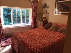米德赫斯特Bridge Cottage的一间卧室设有一张床和一个大窗户