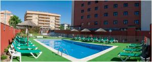 卡塞雷斯埃斯特雷马杜拉酒店的一座带椅子和遮阳伞的游泳池位于一座建筑旁边