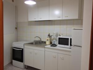 滨海波利尼亚诺Dimora Tarantini的厨房配有白色橱柜、水槽和微波炉
