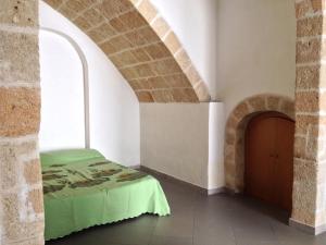 滨海波利尼亚诺Dimora Tarantini的一间带一张床铺的卧室,位于带拱门的房间