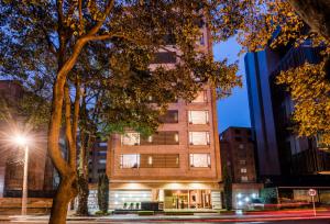 波哥大Hotel Cabrera Imperial By key 33的前面有一棵树的高楼