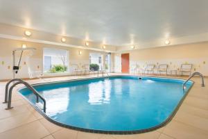 格兰福克Amerivu Inn and Suites的游泳池位于酒店客房内,配有桌椅