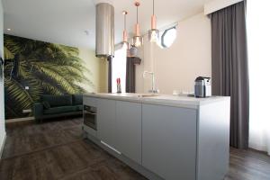 鹿特丹德维特一室公寓的厨房配有白色的柜台和水槽