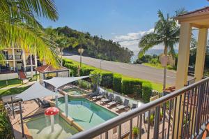麦夸里港南太平洋公寓酒店的阳台设有游泳池和棕榈树