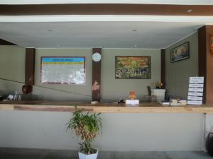 Bumbang龙目岛冲浪花园酒店的餐厅里的一个柜台,墙上挂着一个时钟