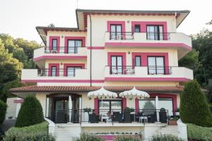 福萨切西亚莱万特酒店的粉红色和白色的建筑设有阳台