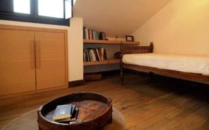 蒙扎第九酒店的一间设有床铺和一张桌子及书籍的房间